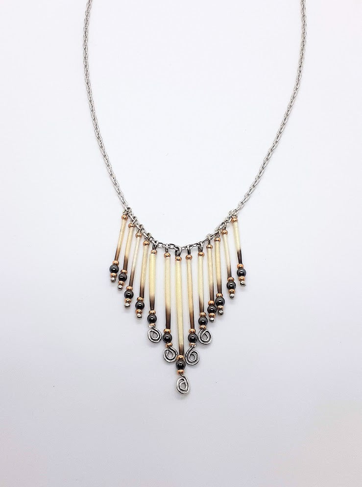 Hematite stone & 24 karat gold plated beads with 13 strand porcupine quills with silver wire. Approximately 21 inch long silver necklace